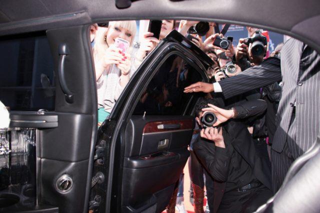 Paparazzi and fans taking photos inside car door